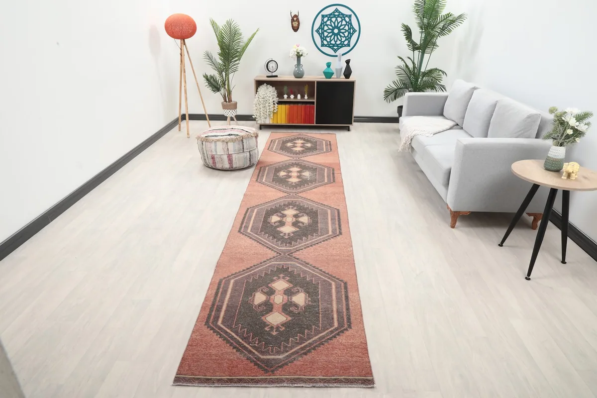 Vintage rust geometric runner displayed in a modern living room setting, showing its long length.