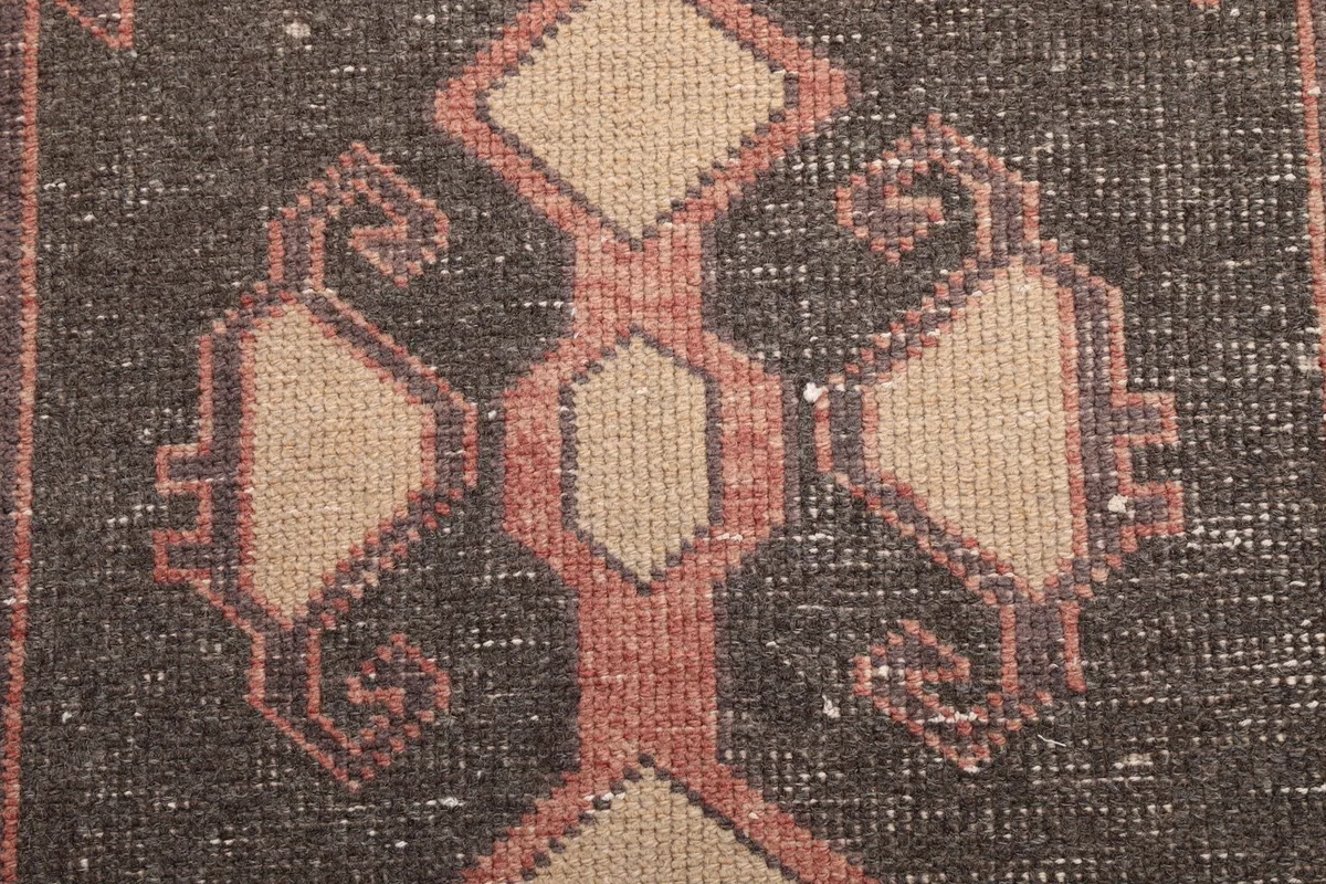 Very close detail of the hand-knotted wool pile within a geometric motif, showing texture and color variation.