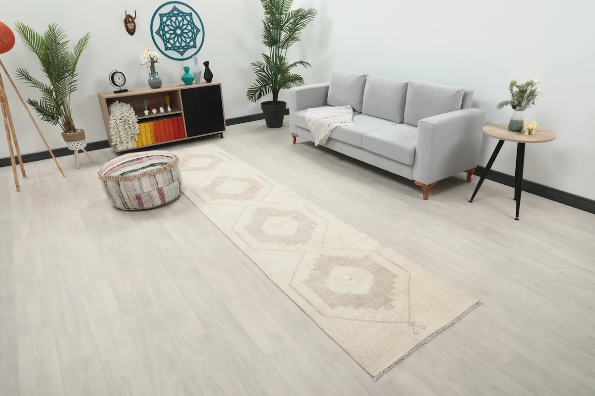 Angle view of the runner rug in a contemporary living space, showing its length and neutral tones.