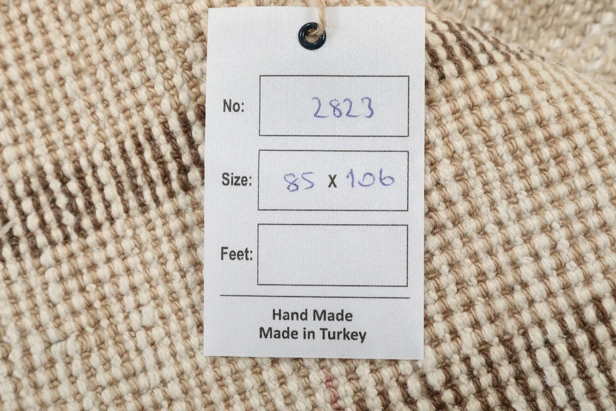 Product tag attached to the rug, indicating it is handmade and made in Turkey.