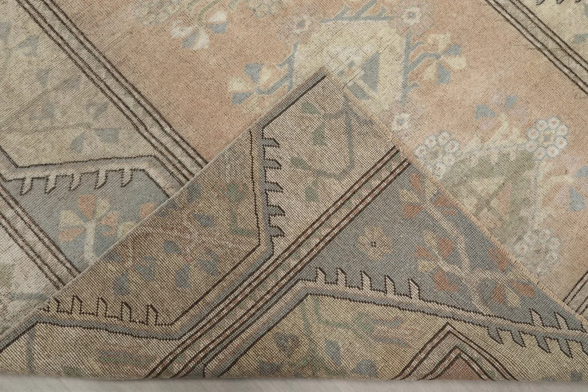 Folded corner showing the rug's reverse side, revealing the hand-knotted cotton foundation