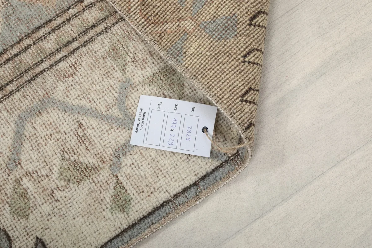 Close-up of the rug's corner with a product tag, showing the hand-knotted detail