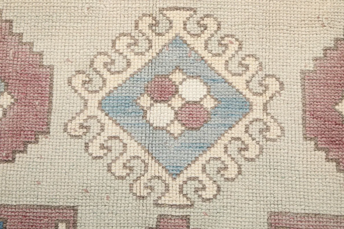 Macro shot of the wool pile and knotting texture in the central blue motif