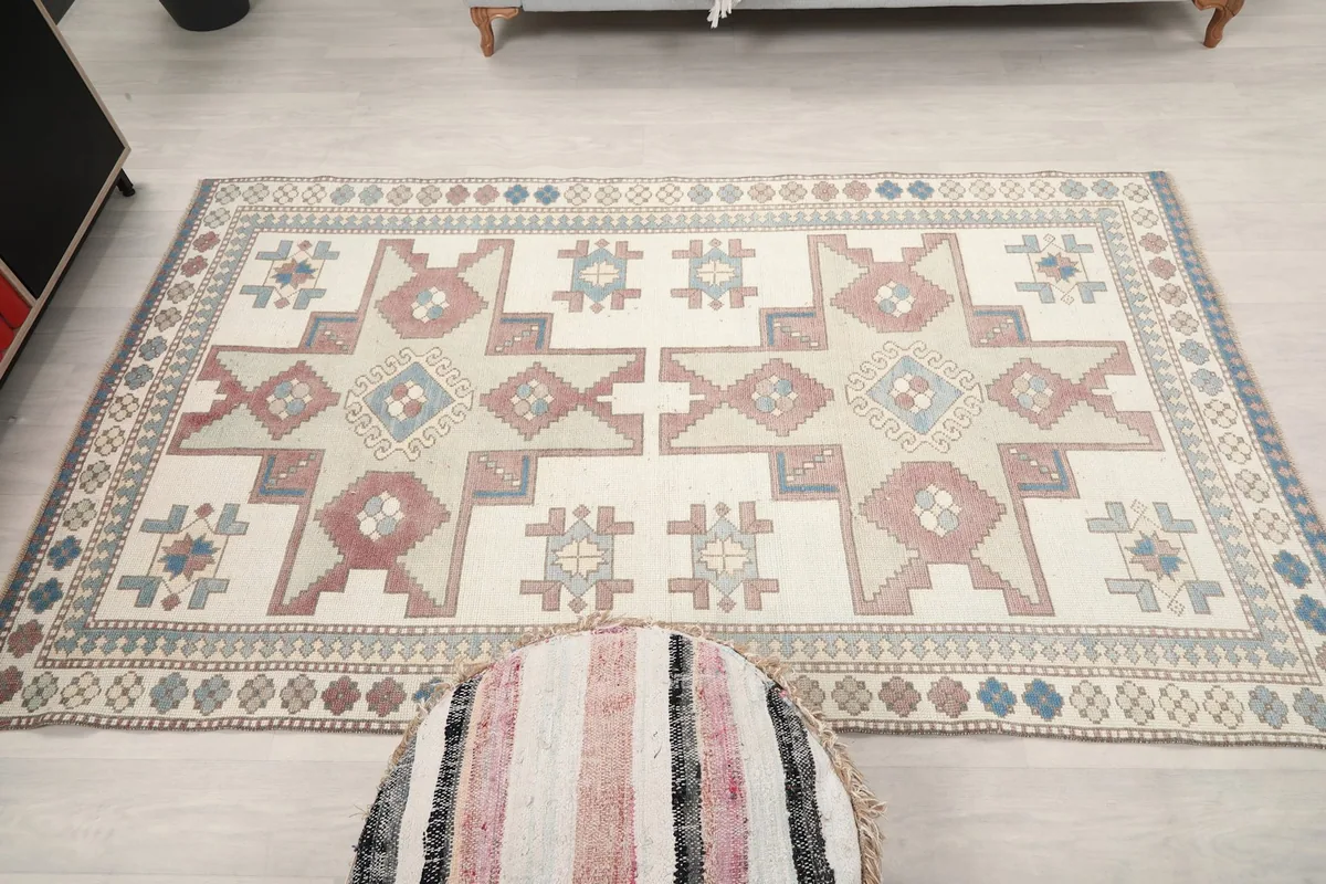 Full overhead view of the rug laid out on a light floor with a decorative pouf