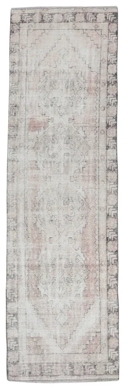 Full overhead view of the beige and rose geometric runner rug on a white background