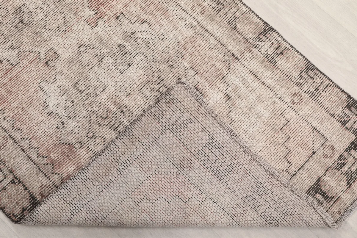 View of the back of the rug, showing the cotton foundation and knotting