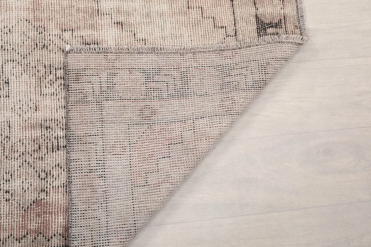 Corner view of the back of the rug, revealing the hand-knotted structure