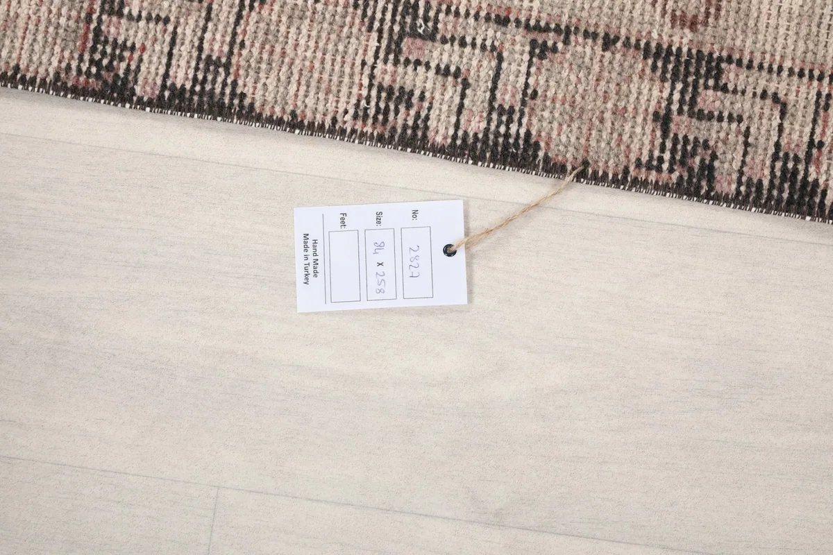 Product tag displaying rug dimensions and type, placed on the floor next to the rug