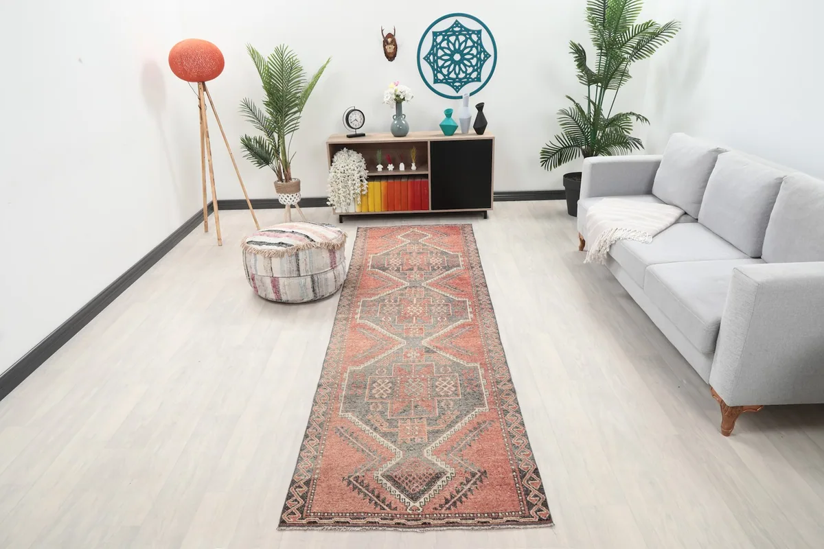 Vintage runner rug in a modern hallway with a gray sofa and plants