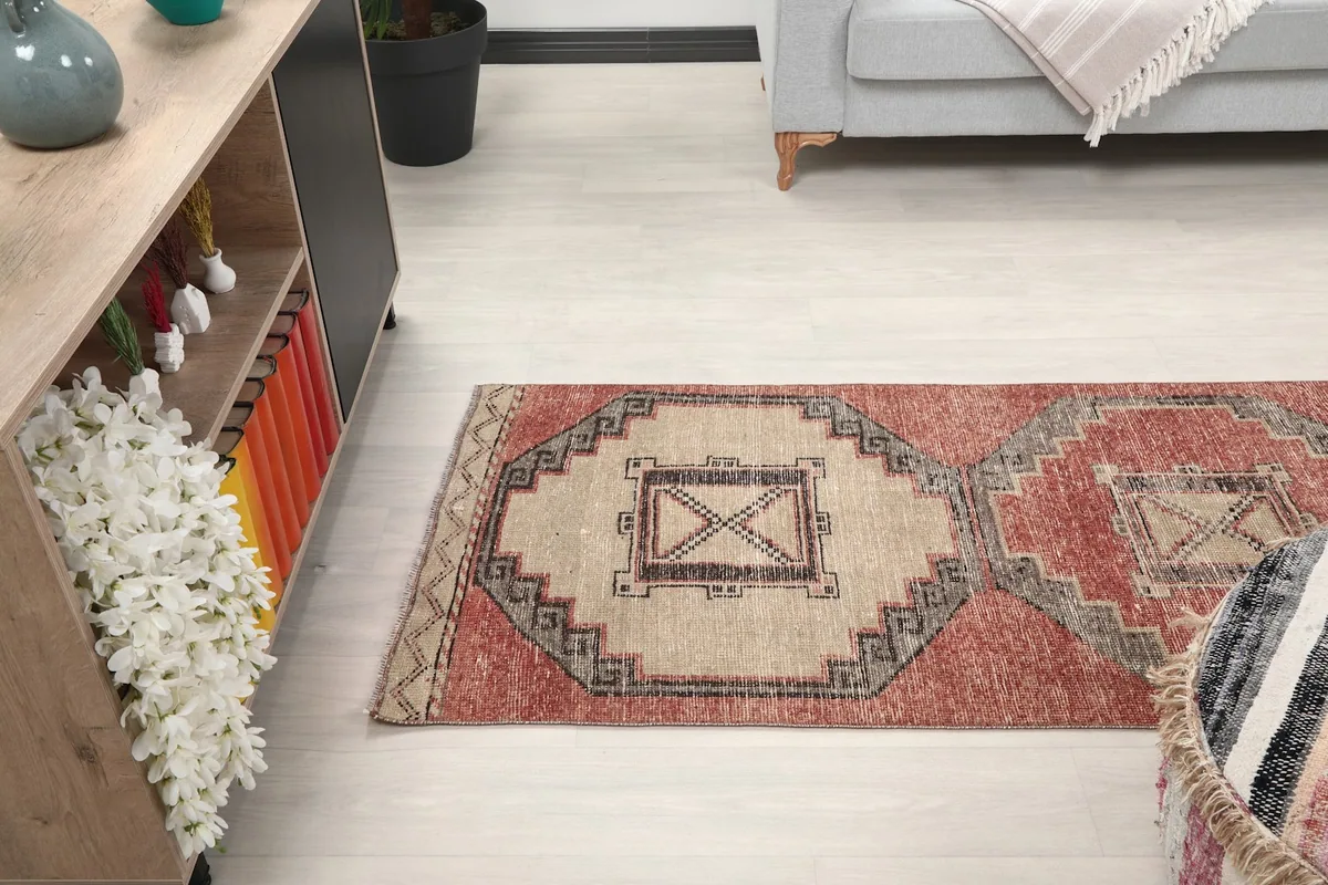 Runner rug extending through a room, viewed from a side angle