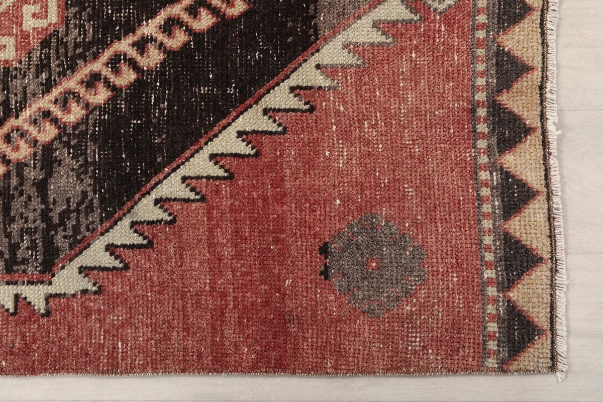 Detailed view of the rust field and a corner of a black geometric diamond motif