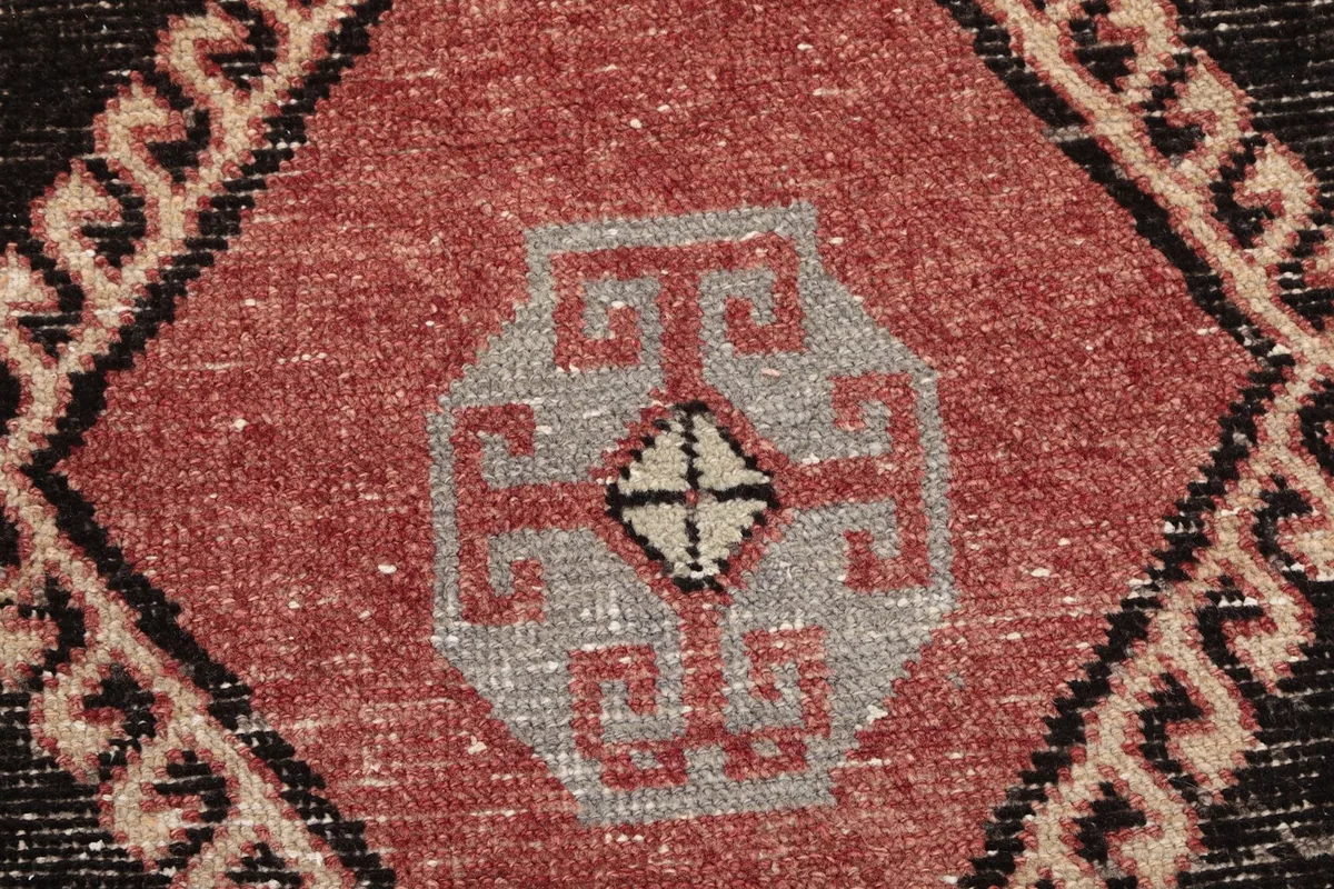 Zoomed-in view of the intricate gray and rust pattern within a black diamond motif