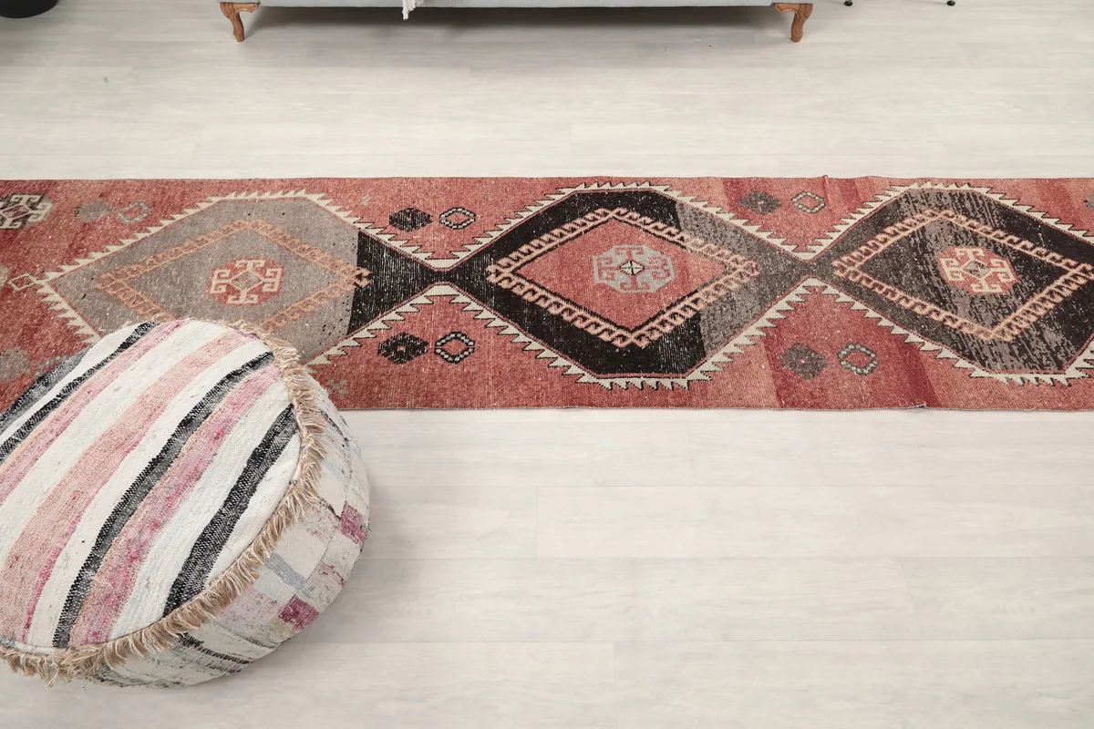 Overhead view of the rug's full length, showing the repeating geometric design and color variation