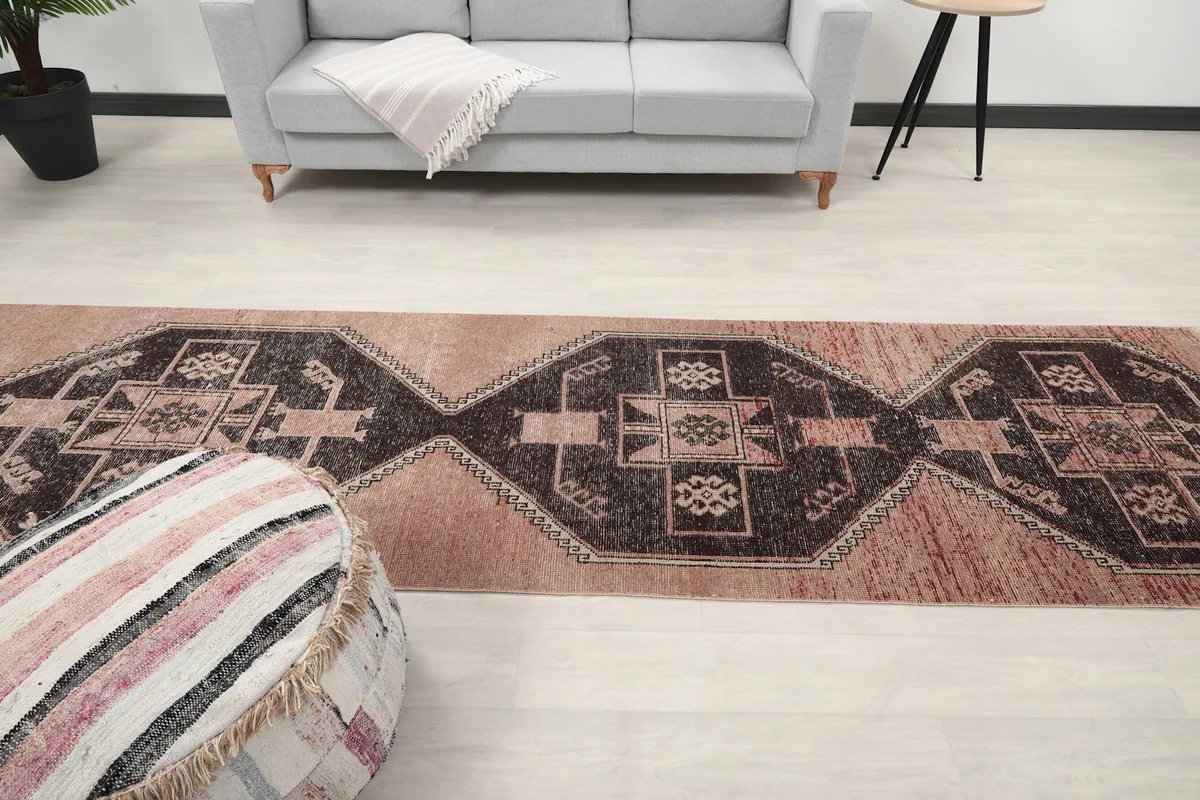 Overhead view showing the full length of the runner rug in the room, with surrounding furniture.
