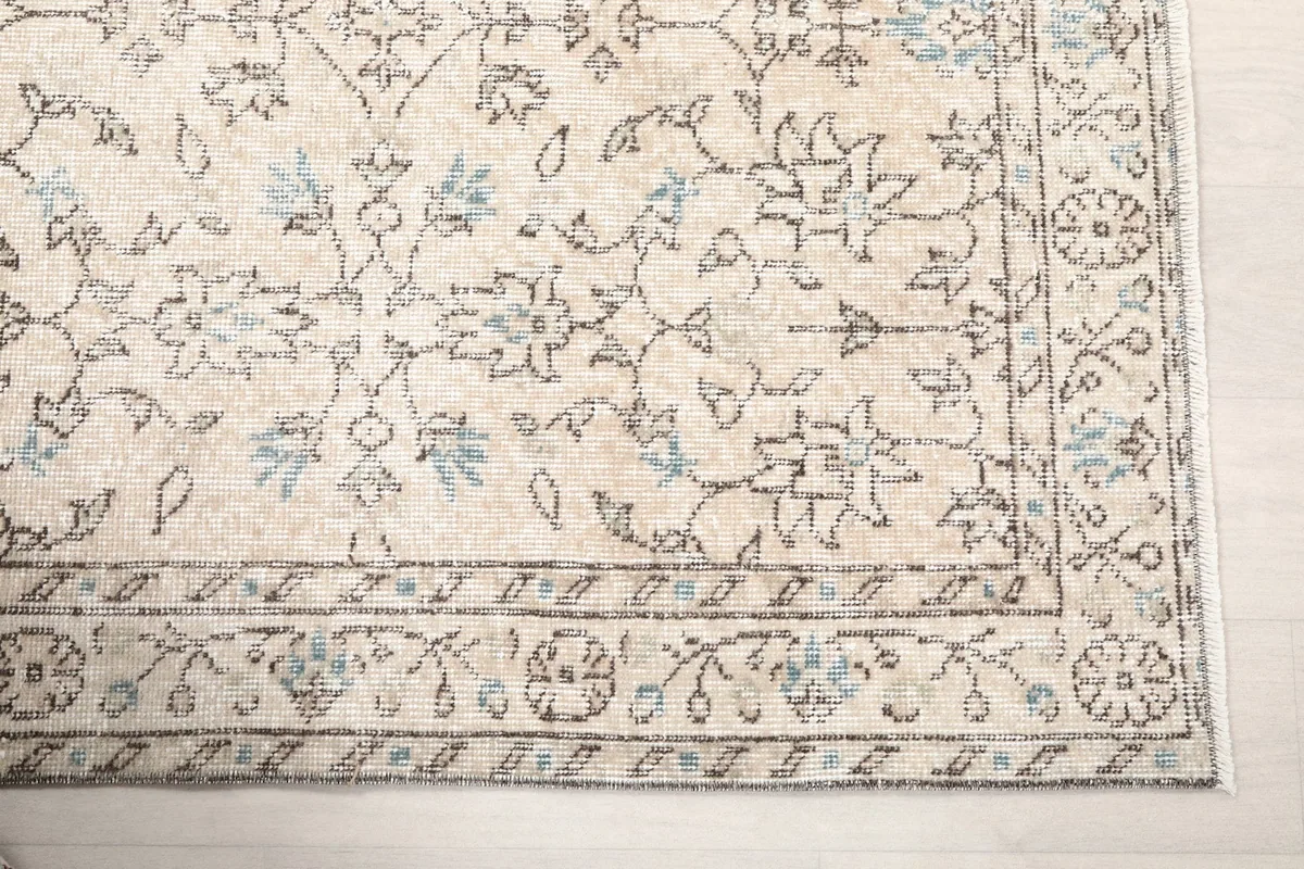 Detailed view of the beige field with gray and blue floral motifs and the patterned border