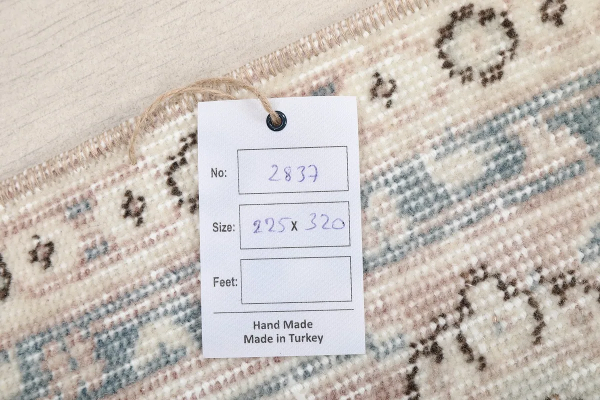 Tag displaying the rug's dimensions in centimeters and 'Hand Made in Turkey'