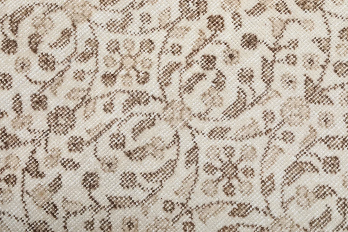 Extreme close-up showing the low pile and hand-knotted wool texture of the rug's pattern.