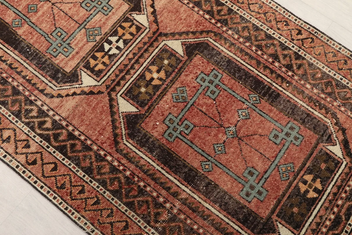 Angled close-up of a geometric medallion with blue details on the rose field