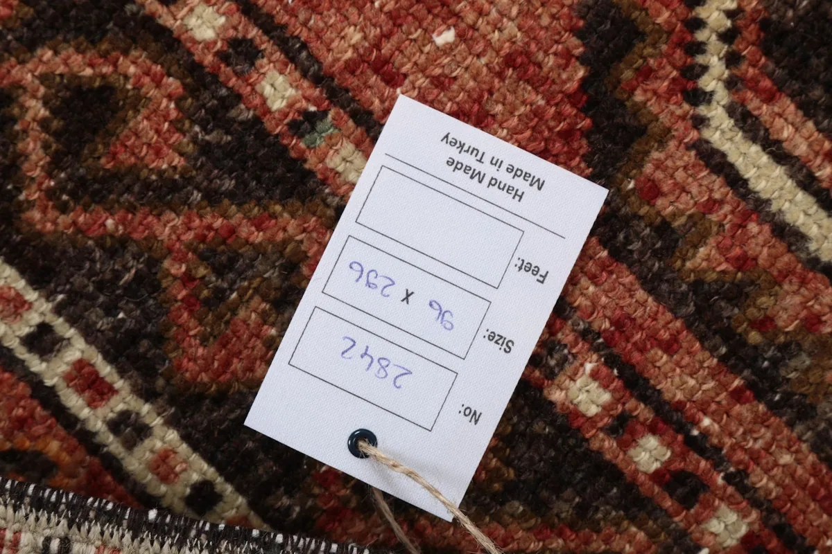 Tag showing the rug's dimensions in centimeters and feet, and handmade origin