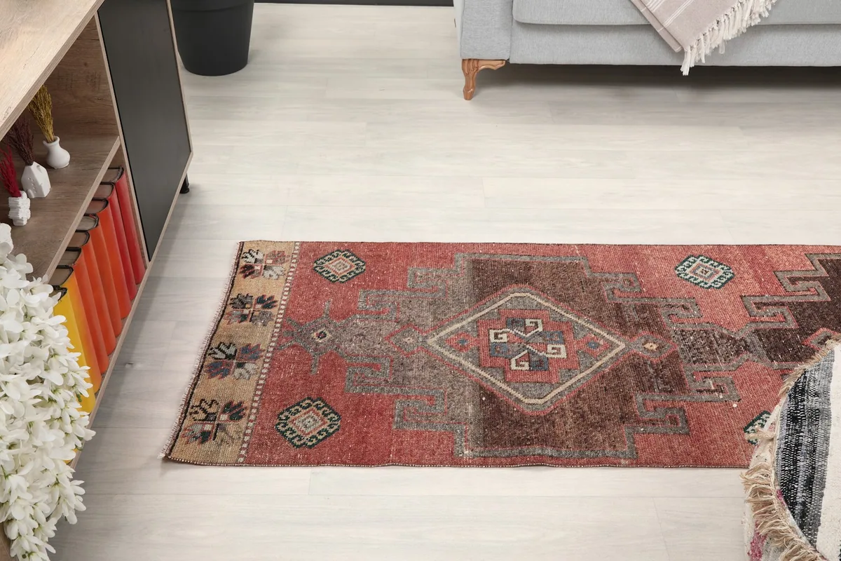 View of the runner rug stretching through a hallway-like space, showing its length.