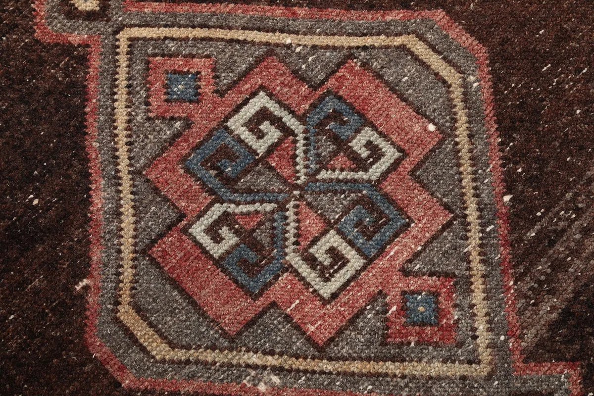 Extreme close-up of a geometric motif within a medallion, revealing blue, gray, and gold accents.