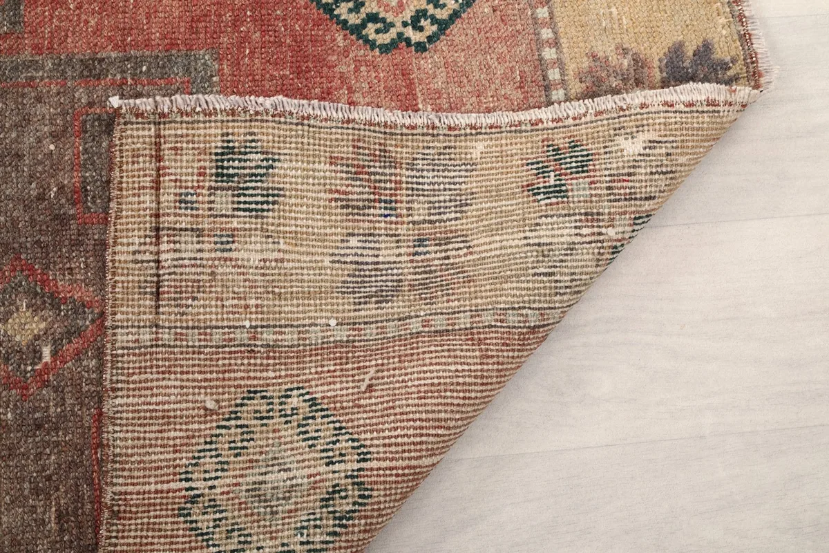 Reverse side detail of the rug, showing the knotting and the structure of the wool pile on cotton.