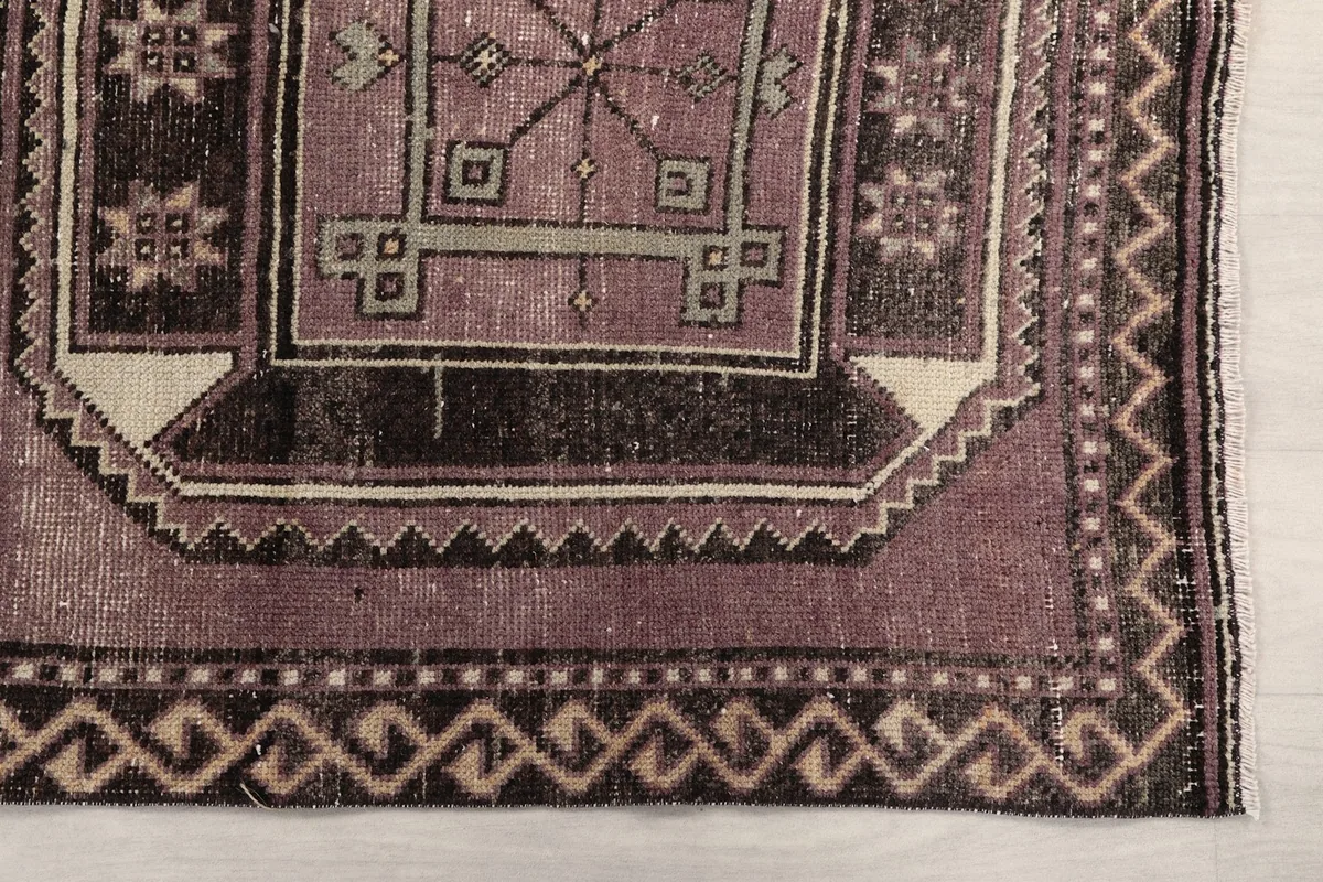 Detailed view of the rug's end, showing a corner of a medallion and border patterns
