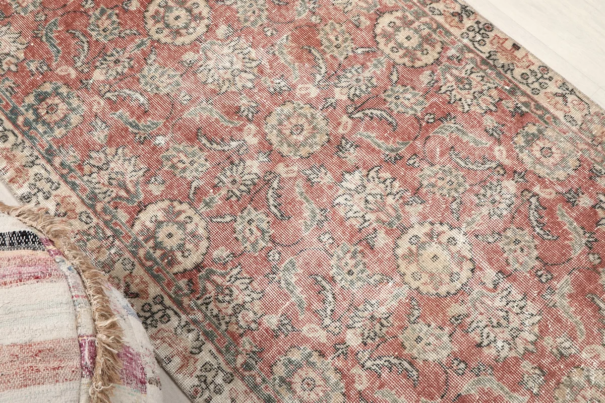 Overhead angle of the vintage rug highlighting its overall design and faded rose color