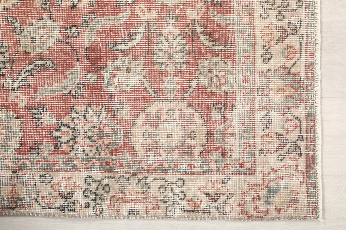 Detailed view of the rug's border pattern in beige, gray, and olive tones