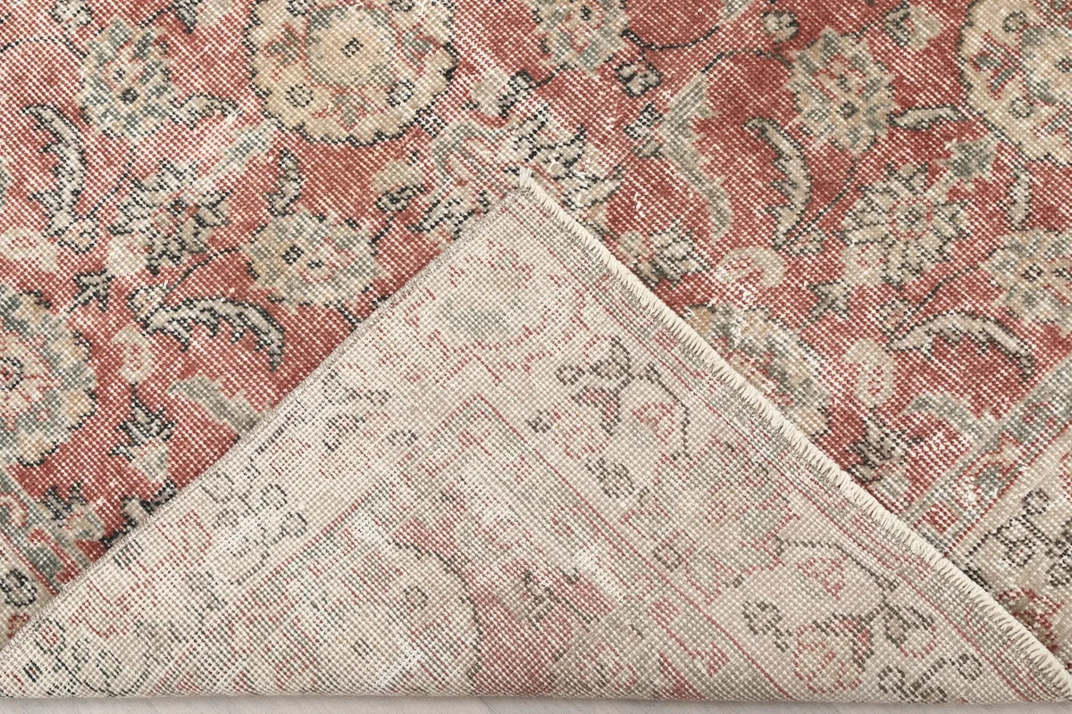 Underside corner of the hand-knotted wool rug, revealing the cotton foundation