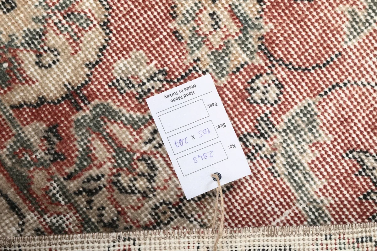 Close-up of the rug's texture with a product tag showing dimensions in centimeters