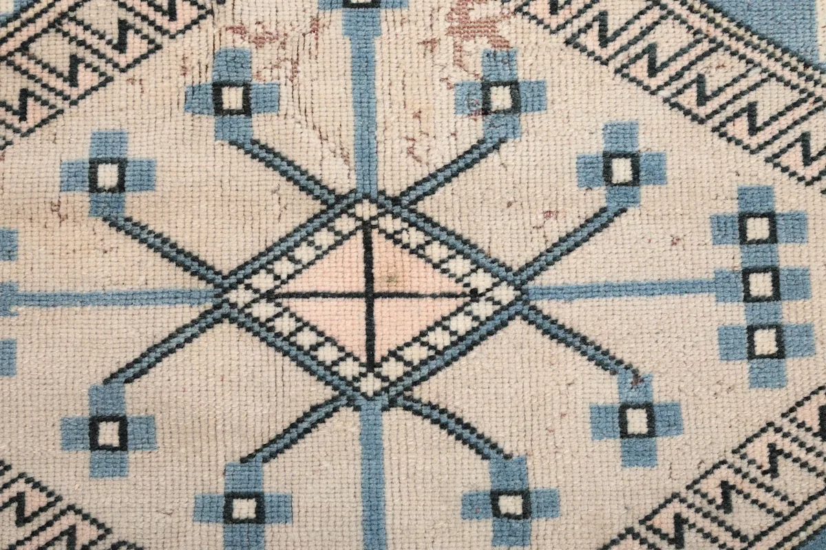 Close-up of a central diamond motif, showing knot detail and color variations.