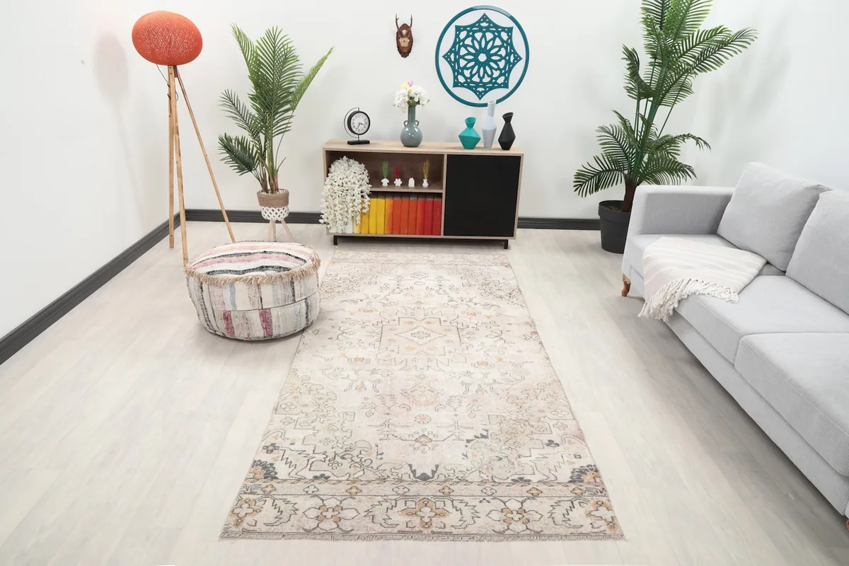 Ivory and rose geometric rug in a living room setting with a light gray sofa