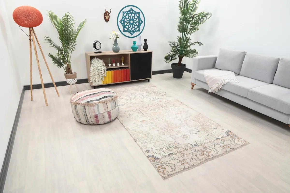 Overhead angle of the ivory and rose rug in a living room, showing its full length