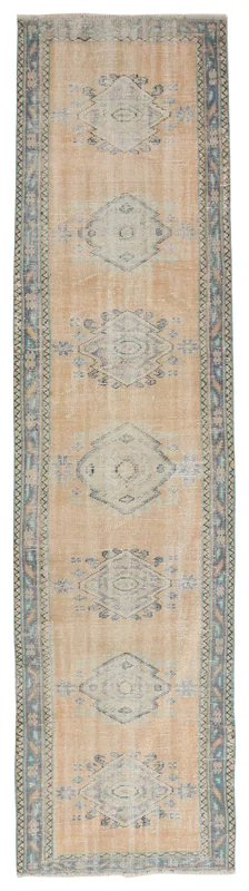 Full overhead view of the beige and blue tribal vintage Anatolian runner rug on a white background.