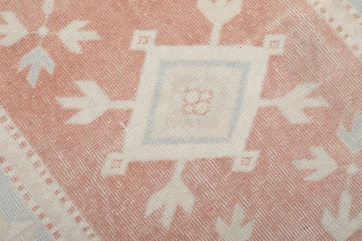Close-up of the central medallion design with rust and cream tones
