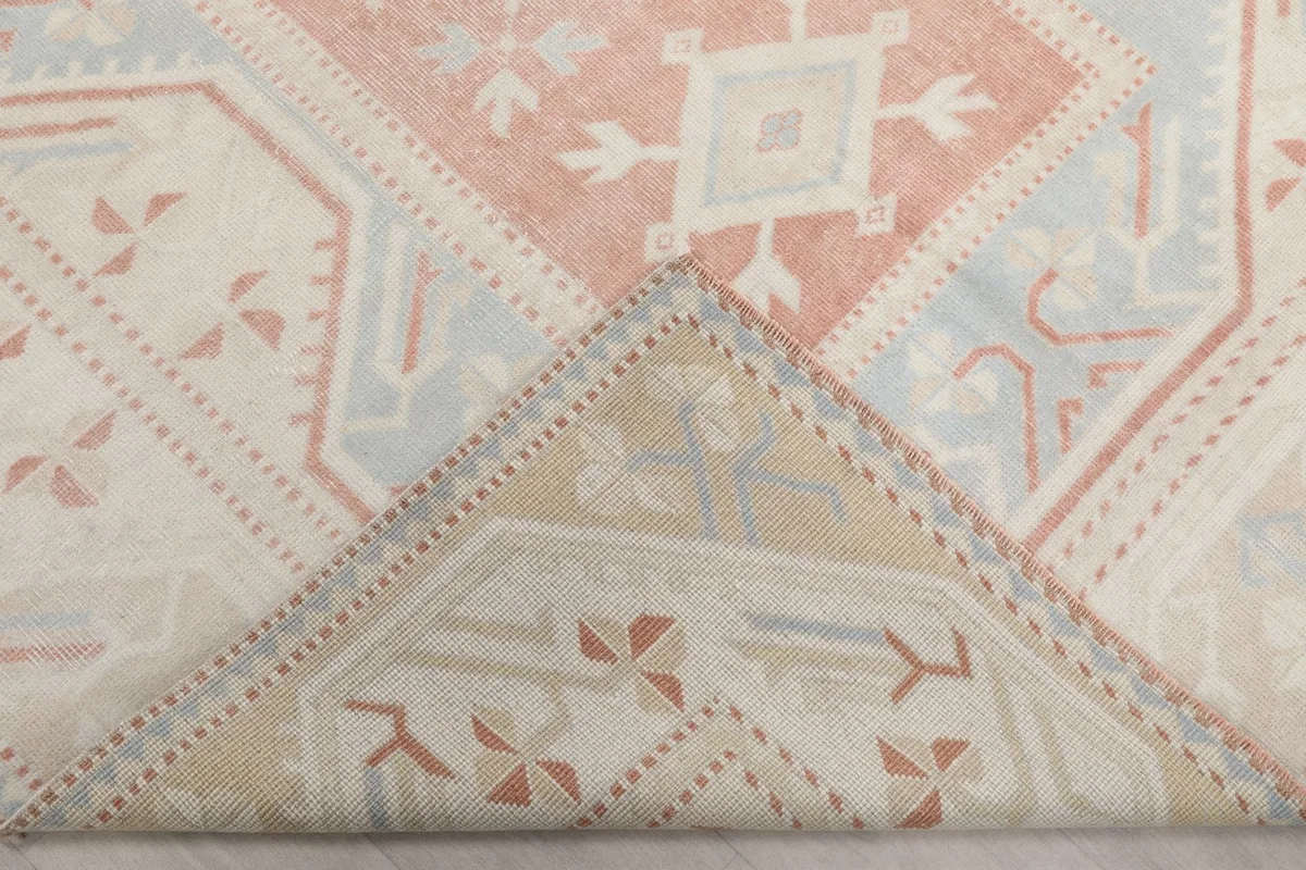 Corner of the rug folded back, revealing the reverse side and knotting