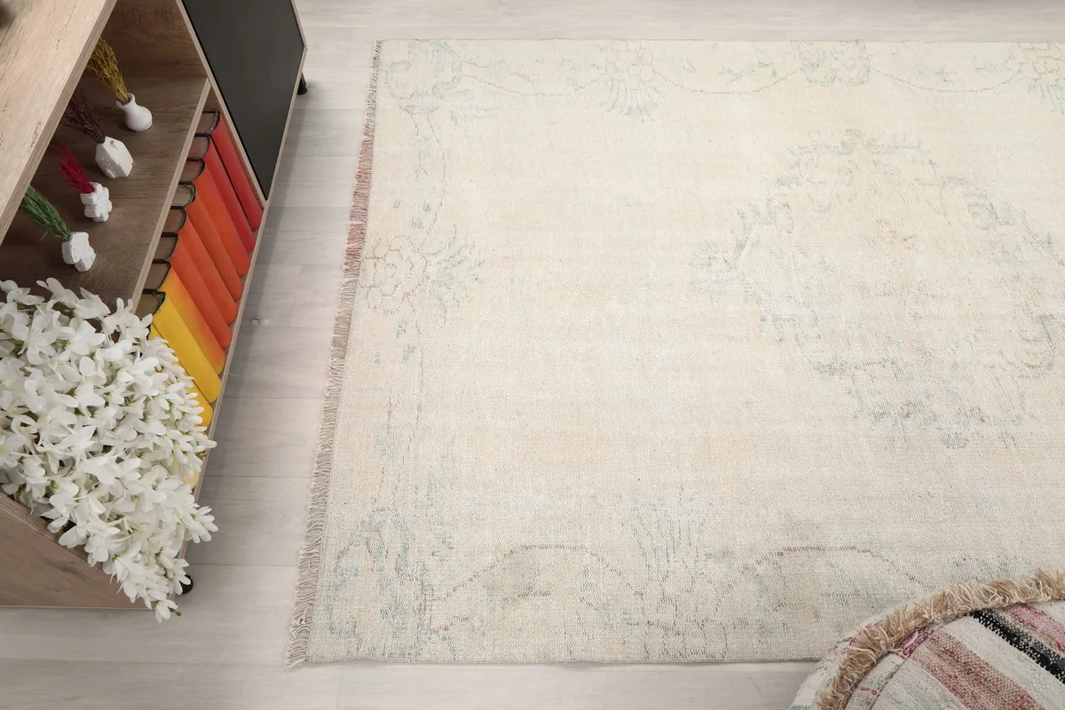 Angled view of the rug's side, showcasing the consistent faded pattern across the field.