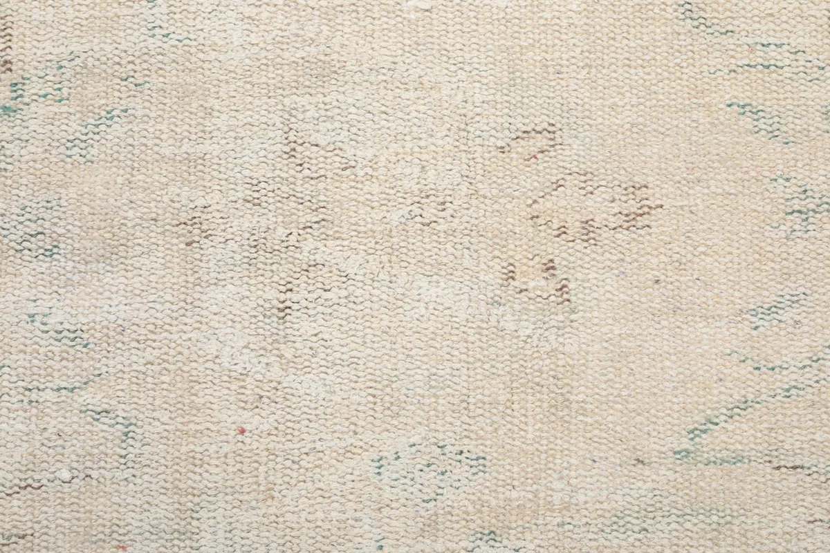 Texture shot of the rug's low wool pile, showing the hand-knotted construction and natural wear.