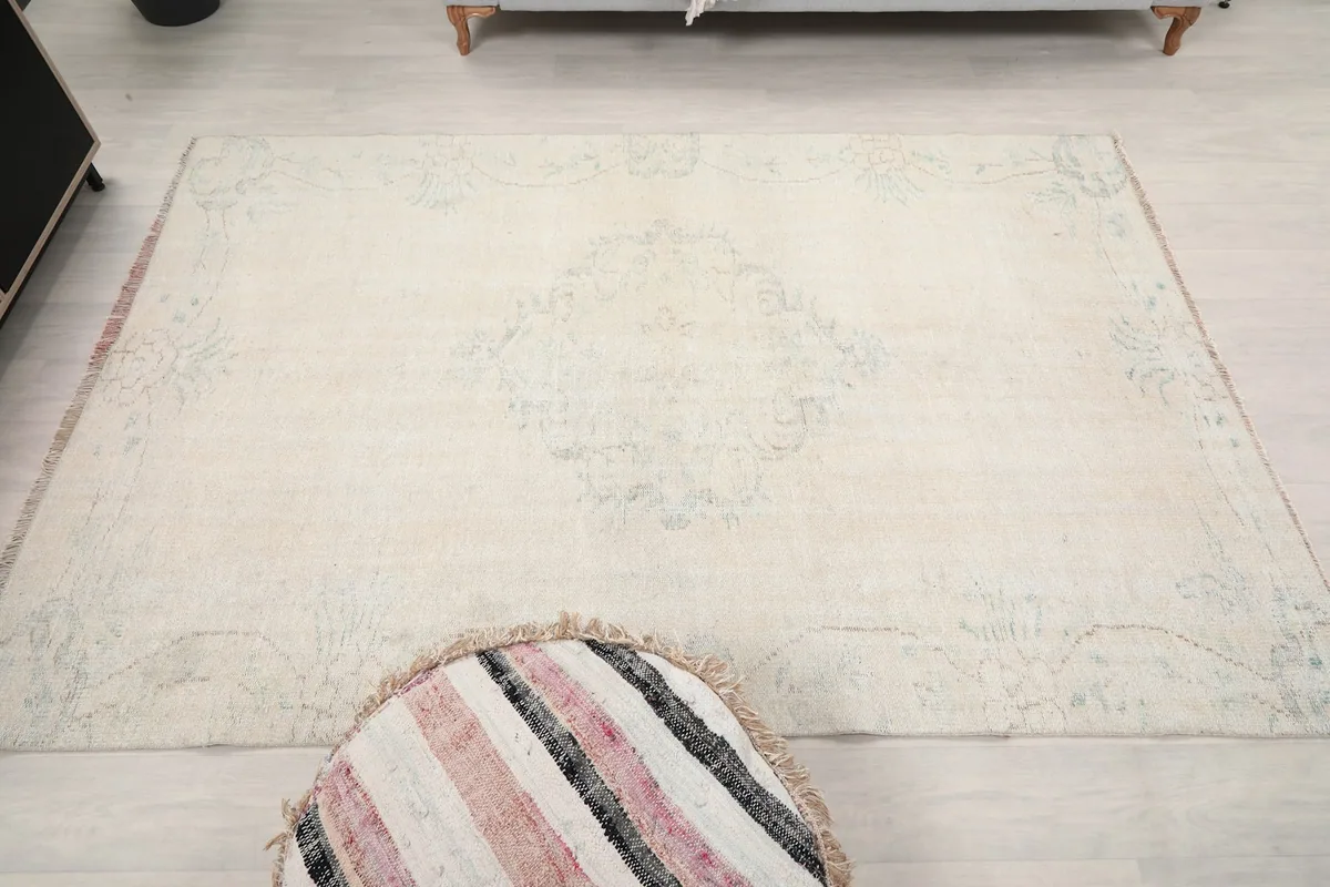 Full overhead view of the rug on a light floor, emphasizing its muted colors and design.