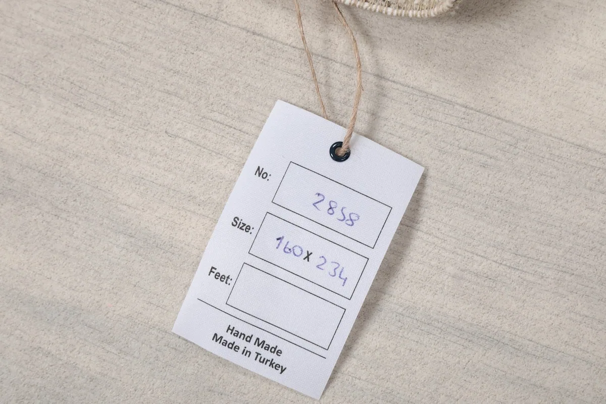 Product tag indicating the rug's size in centimeters and its origin as hand-made in Turkey.
