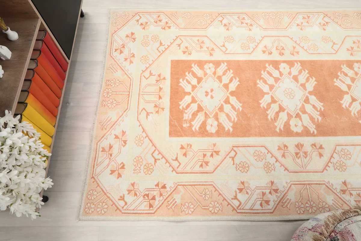 Angled view highlighting the rug's border and main field, with surrounding room elements.