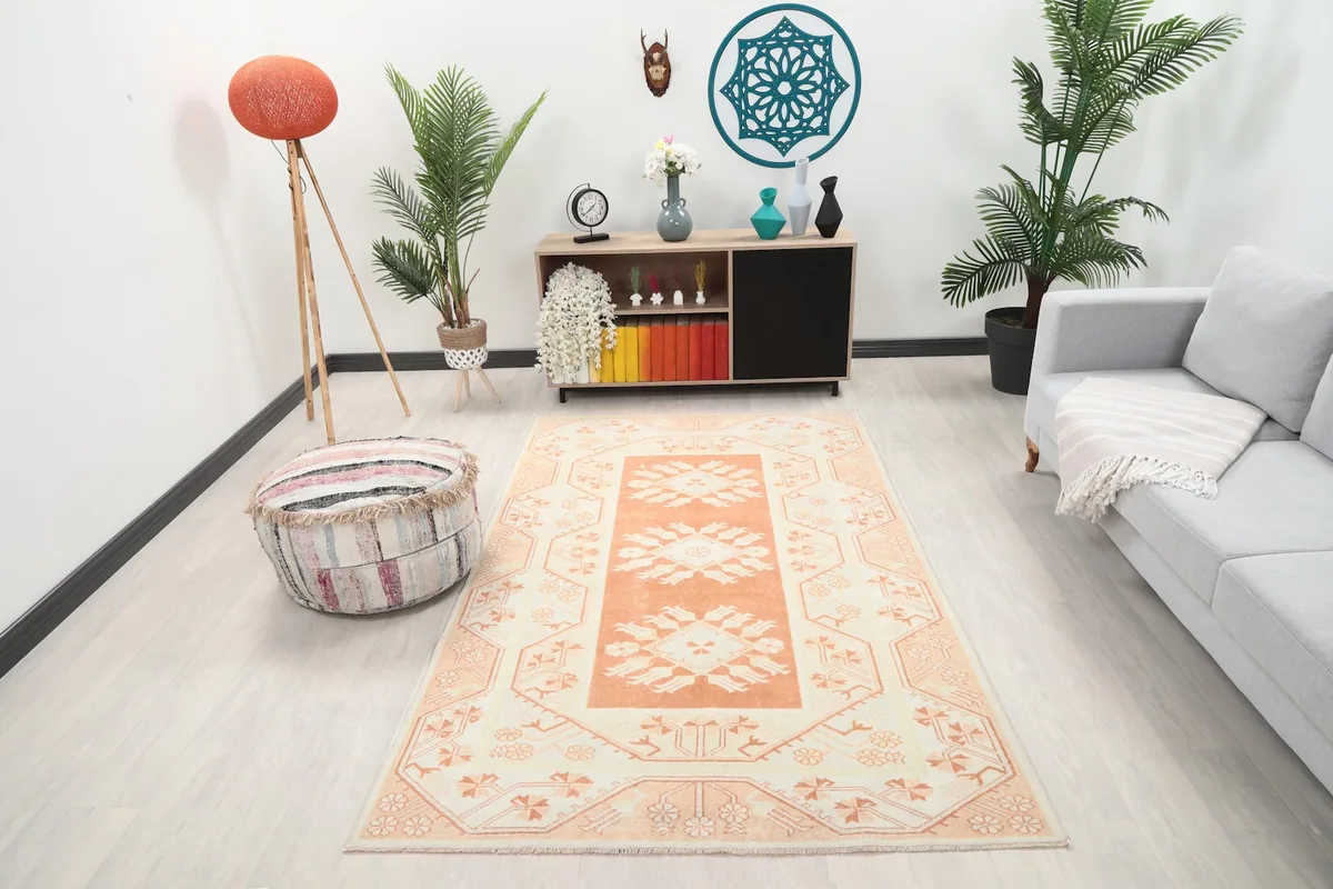 Vintage Anatolian rug displayed in a living room setting, showing its scale and color next to furniture.
