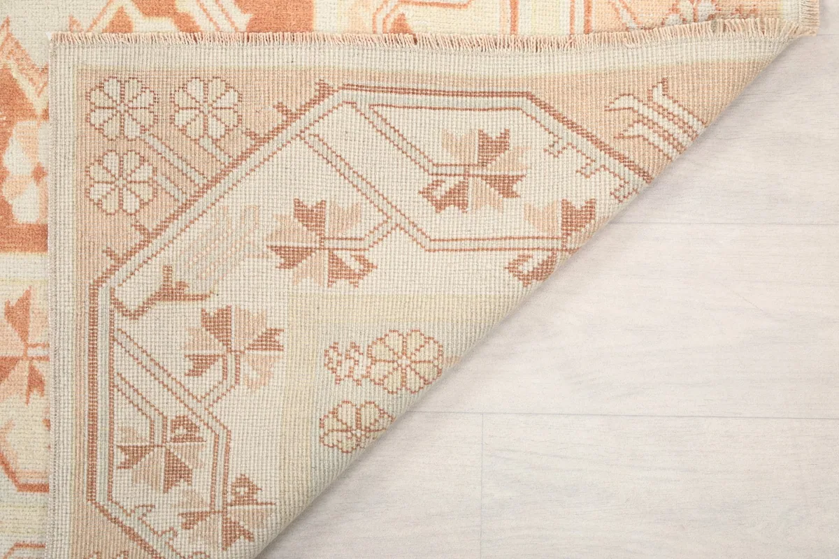 Corner flipped to show the back of the rug, detailing the knotting and fringe.