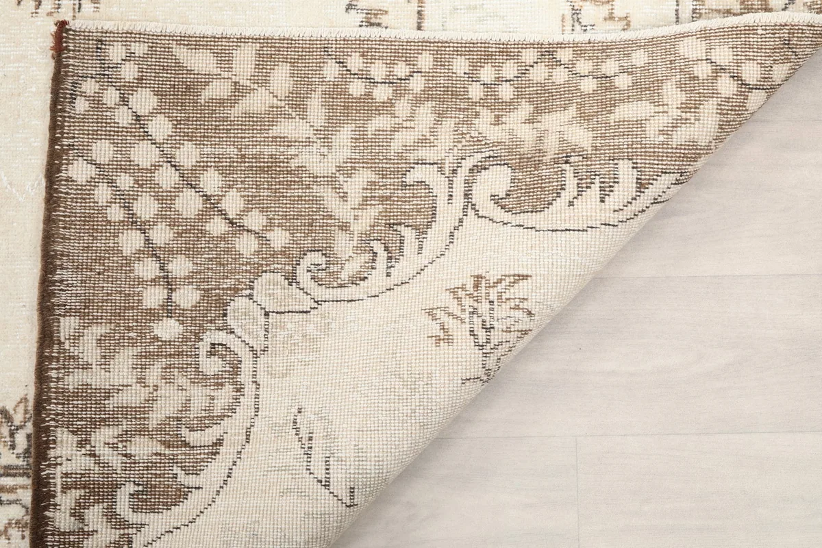 View of the rug's reverse side, revealing the cotton foundation and knotting