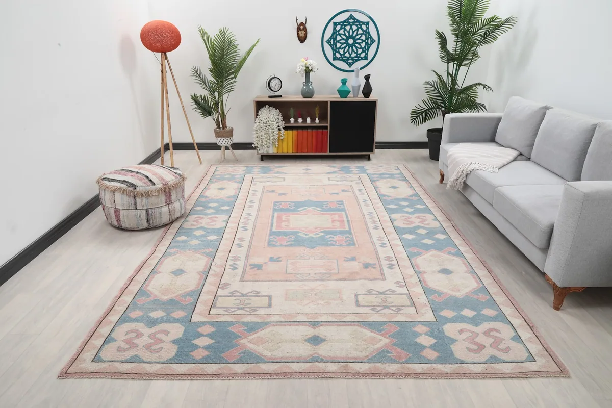 Vintage Anatolian rug displayed in a living room setting with a light gray sofa and plants