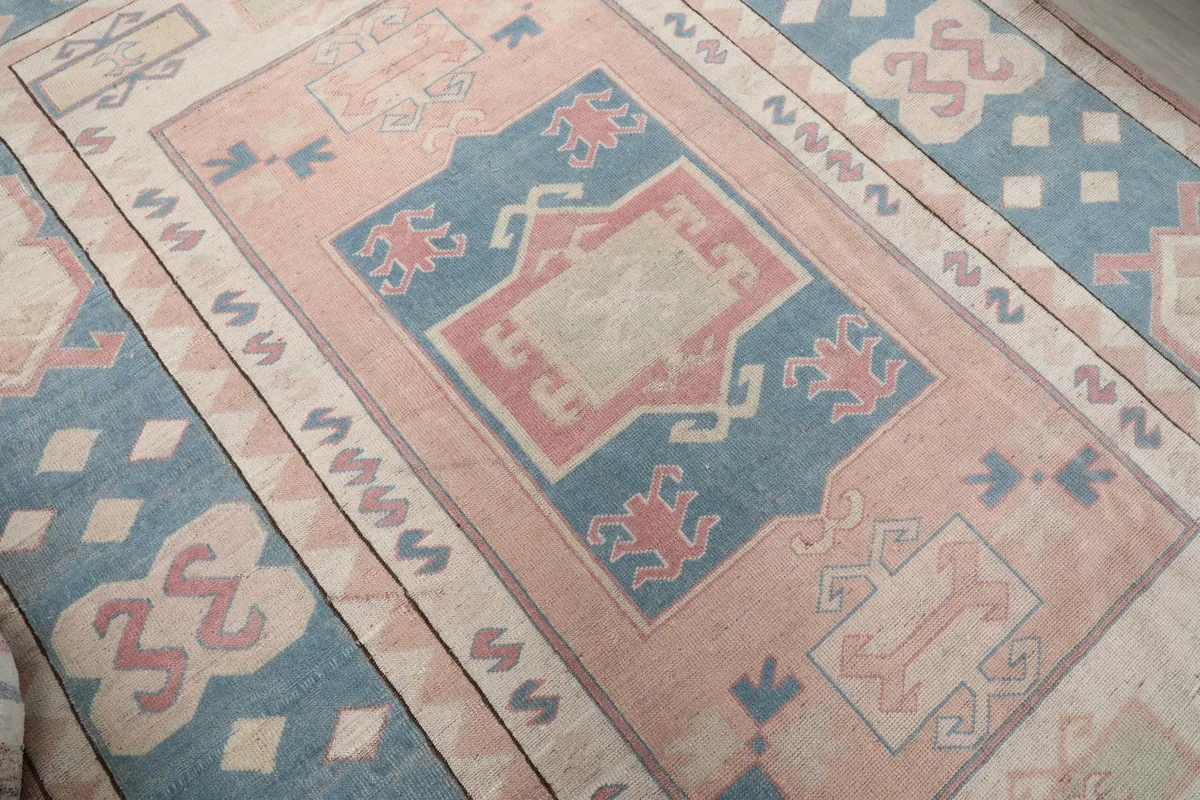 Close-up of the rug's central rose medallion and surrounding blue and ivory geometric patterns