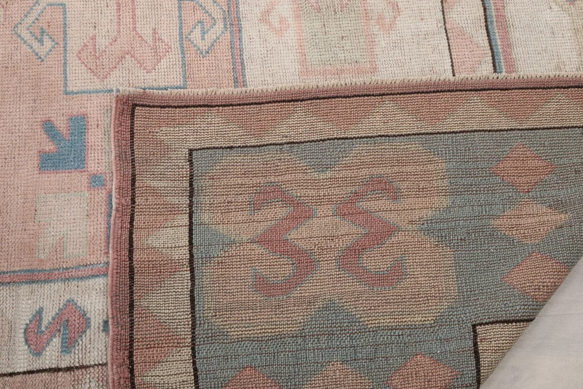 Close-up of the folded rug corner, showing the tight knotting on the back and the rug's construction