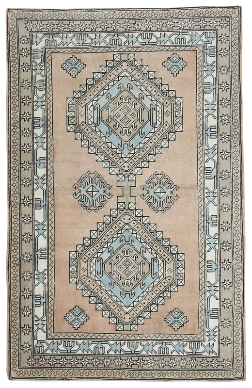 Full overhead view of the tan and blue geometric vintage Anatolian rug on a white background.