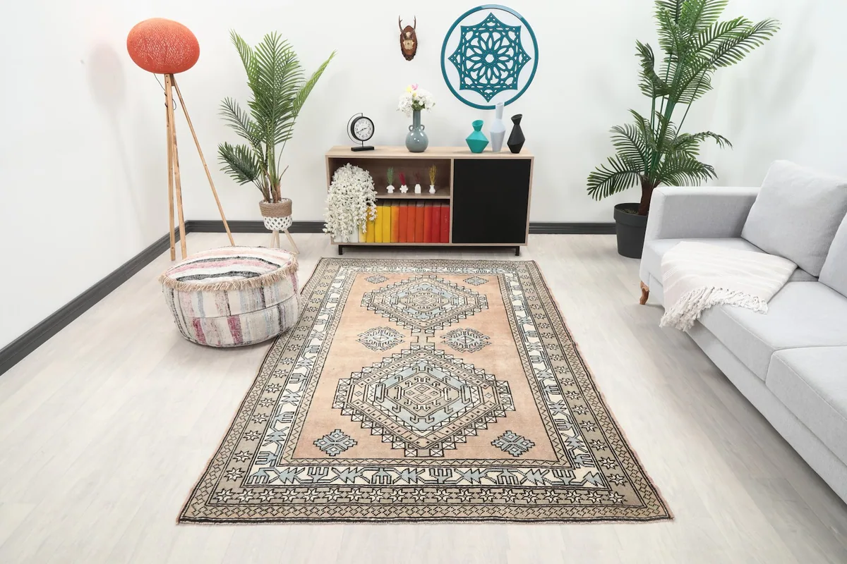 Vintage tan and blue geometric rug displayed in a bright living room setting with modern furniture.